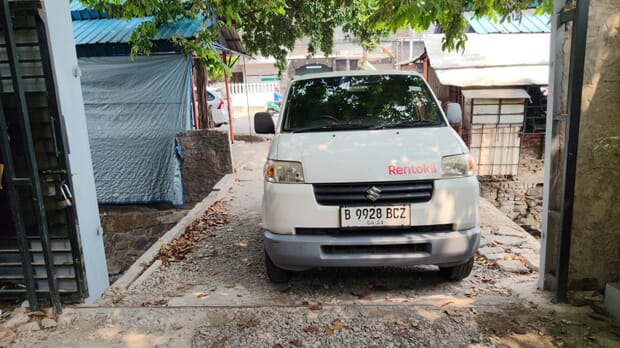 Akses sempit di sisi bangunan dengan kendaraan terparkir
