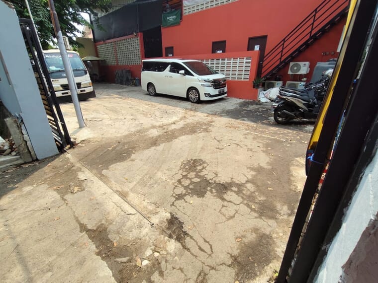 Coran lama yang retak di area parkir lapangan padel Cipinang sebelum dikerjakan