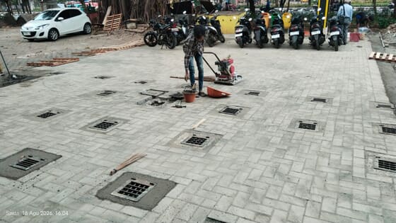 Penebaran abu batu pada celah paving di Pasar Minggu